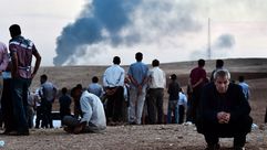 أكراد يشاهدون التفجيرات في عين العرب كوباني على الحدود التركية السورية - ا ف ب