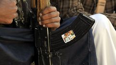 مسلح يضع صور زعماء الحوثيين على سلاحه في صنعاء - الأناضول