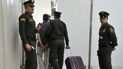 عناصر من شعبة مكافحة المخدرات في الشرطة الكولومبية يوقفون مسافرا في مطار بوغوتا