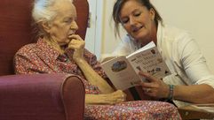 متطوعة من جمعية خيرية تقرأ اشعارا لمسنة تعاني من الخرف في مركز في ستراتفورد ابون ايفون - ا ف ب