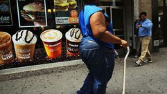 سيدة تمر امام متجر يبيع مشروبات سكرية في احد احياء بروكلين حيث ترتفع نسبة البدانة والاصابات بالسكري،