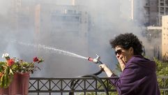امرأة إسرائيلية تحاول رش محيط منزلها بالمياة خوفا من احتراقه- أ ف ب