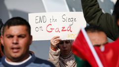 سيدة ترفع لافتة لكسر الحصار عن غزة- جيتي