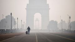 رجل يمشي في 15 تشرين الثاني/نوفمبر 2020 قرب "بوابة الهند" في نيودلهي وسط سجب كثيفة من التلوث
