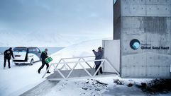 علماء أمام مخزن للحبوب العالمي في جزيرة قطبية- جيتي