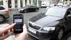 تطبيق اوبر على هاتف ذكي امام سيارة اجرة في باريس في 10 كانون الاول/ديسمبر 2014