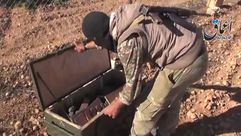 أحد مقاتلي الدولة الإسلامية يفتح صندوق أسلحة أمريكي غنمته الدولة بكوباني ـ تويتر