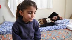 طفلة سورية مع ابيها اللاجئ الذي فقد سمعه وبصره ترك برس