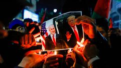 فلسطينيون يحرقون صور ترامب نتنياهو خلال مظاهرة رفضا لصفقة القرن - جيتي