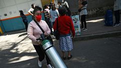 فتاة تدفع قارورة أوكسجين فيما ينتظر آخرون لتعبئة قوراريهم في مكسيكو في 22 كانون الثاني/يناير 2021