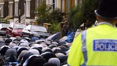 شرطي يراقب مسلمين يصلون خارج مسجد فينسبري بارك في لندن - أ ف ب