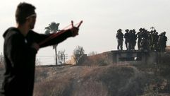 شباب يرشق قوات الاحتلال بالحجارة خلال المواجهات بالضفة- جيتي