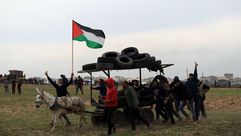 عربة تحمل إطارات لإشعالها بوجه الاحتلال خلال المواجهات في غزة - جيتي