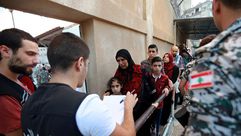 عناصر من الأمن اللبناني خلال تفقد مجموعة من اللاجئين السوريين قبل إعادتهم لبلادهم- جيتي