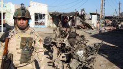 جندي عراقي أمام سيارة محترقة ببغداد – أ ف ب