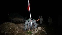 جنود يرفعون علم تركيا بمنطقة آشمة تمهيدا لنقل رفات سليمان شاه إليها - أرشيفية