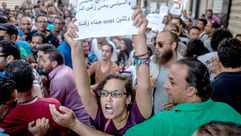 محتجة تونسية ترفع لافتة ضد المال السياسي في تونس- أرشيفية