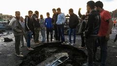 عراقيون يتجمعون أمام حفرة تسببت بها السيارة المفخخة- أ ف ب