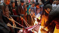 إيرانيون يحرقون العلم الأمريكي أمام سفارة أمريكا في طهران 2018 - جيتي