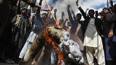متظاهرون باكستانيون يرفعون شعارات أمام تمثال محترق لرئيس الوزراء الهندي ناريندرا مودي - جيتي