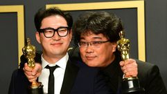 كاتب فيلم "باراسايت" هان جين وون (يسار) إلى جانب بونغ جون-هو بعد تسلمهما جوائز الأوسكار في هوليوود ف