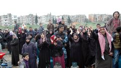 العشرات من السوريين ينتظرون المساعدات في أحد أحياء حمص - ا ف ب