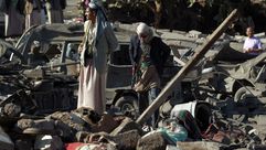 عناصر حوثية فوق ركام أحد مقراتهم بعد قصف طائرات التحالف - أ ف ب