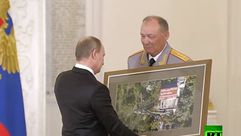 بوتين يتسلم صورة هدية من جيشه في سوريا سبوتنيك