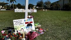 زهور أمام صليب نصب تكريما لضحايا مجزرة جرت في مدرسة في باركلاند في فلوريدا قرب المؤسسة التربوية في 1