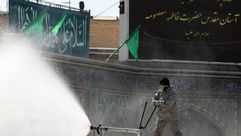 فرق مكافحة الأوبئة الإيرانية خلال رشم مواد تعقيم في أحد مراقد قم- إرنا