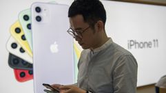 رجل يجرب طرازا جديدا من هواتف "آي فون" في متجر تابع لمجموعة "آبل" في هونغ كونغ في 20 أيلول/سبتمبر 20