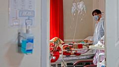 طبيب إيراني يعالج مريضا مصابًا بفيروس كورونا في أحد مستشفيات طهران - جيتي
