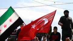 معارضون للأسد يرفعون علم الثورة السورية إلى جانب علم تركيا - (أرشيفية)