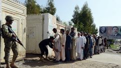 شرطي أفغاني يقوم بتفتيش الناخبين قبل الإدلاء بأصواتهم - ا ف ب