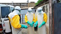 عاملون طبيون ينظفون ملابسهم ضمن حملة مكافحة فيروس ايبولا في مستشفى دونكا في كوناكري