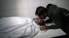 شاب يقبل شقيقه الشهيد في غزة جيتي