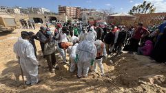 فرق الدفاع المدني خلال انتشال جثامين الشهداء من مقبرة جماعية بساحة مستشفى ناصر- الأناضول