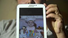 نتاليا رينكون تعرض صورة الطفل خوسيت دياز الذي صمد ثلاثة ايام وحيدا بعد انزلاقات التربة في سالغار شما