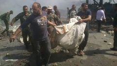 عناصر النظام السوري ترفع الجثث من مكان التفجير- فيسبوك