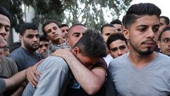 شاب فلسطيني يبكي شقيقه الذي استشهد في مجزرة غزة - جيتي