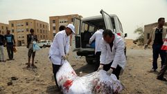 رجل يمني يحمل جثمان ضحية في غارة جوية - جيتي