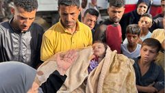 أب يحمل طفلته الشهيدة خارج مستشفى شهداء الأقصى- حساب الصحفي إياد عيد