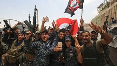 عناصر من الشرطة العراقية يحتفلون باستعادة الموصل - أ ف ب
