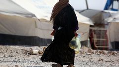 امرأة سورية بجانب مخيم للاجئين - جيتي