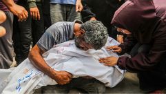 أب فلسطيني يحضن جثمان طفله الشهيد- الأناضول