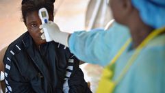 قياس حرارة فتاة يشتبه في اصابتها بمرض ايبولا في مستشفى حكومي في كينيما في سيراليون في 17 اب/اغسطس 20