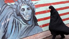 إيرانية تمر أمام جدارية تهاجم أمريكا - (أرشيفية) أ ف ب
