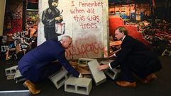 موظفان من دار جوليينز يجهزان لوحة بانكسي لعرضها للمزاد، في بيفرلي هيلز - أ ف ب