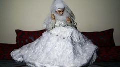 سورية، اضطرتها الحرب لإلغاء خططها للزواج، تحاول ارتداء فستانها في منزلها الجديد في تركيا - الأناضول