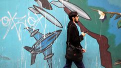 إيراني يمر بجانب لوحة جدارية على السفارة الأمريكية في طهران - جيتي